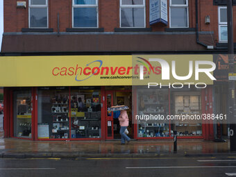 A person passing a Cash Converters store and payday loan company in Manchester. (
