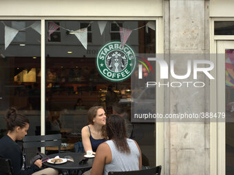 People sitting outside a Starbuck's coffee shop in Manchester city centre. (