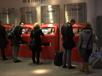 People purchasing travel tickets at a railway station in Manchester. (