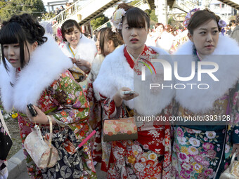 Japanese women in kimonos pose for pictures after a ceremony celebrating Coming of Age Day in Tokyo January 12, 2015.  Age twenty is conside...