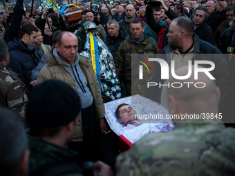 People carrying the coffin of a body of a dead anti-government demonstrator killed in yesterdays clashes with police is lifted above the cro...