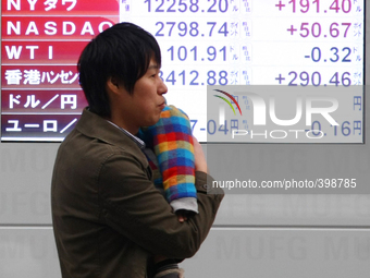 A man walks past a stock quotation board outside a brokerage in Tokyo January 18, 2015. (