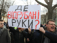 Opponents of Ukrainian President Petro Poroshenko hold a poster reading 'Where are the severed hands?', during a meeting Poroshenko with peo...