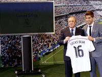Brazilian football player Lucas Silva poses with his new shirt next to Real Madrid president Florentino Perez during his presentation as new...