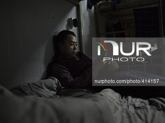 A migrant from Sichuan rests inside workers' temporary dormitory after a day of work on January 30, 2015 in Shenzhen. Thousand of people all...