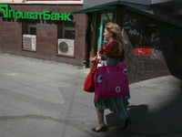 A woman walks past the entrance of the branch of Privat Bank in Kyiv, Ukraine, April 26, 2019. Kyiv District Administrative Court ruled that...