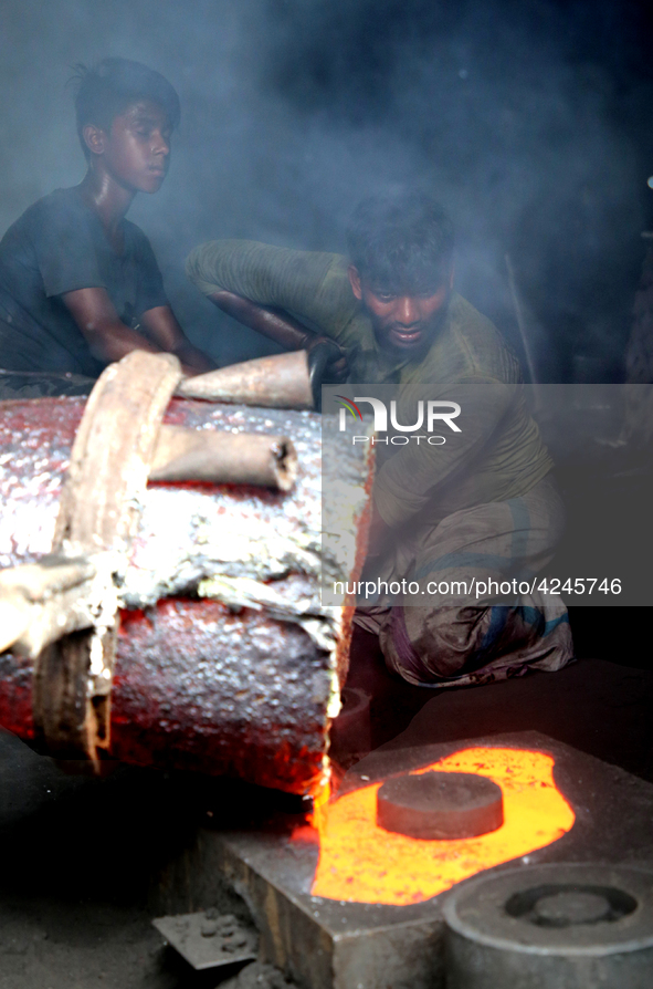 Liquid iron is flowing into the prepared propeller mould at a dockyard on the bank of River Buriganga in Dhaka, Bangladesh 