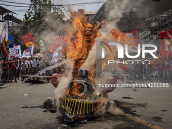 Protesters burn an effigy of Philippine President Rodrigo Duterte during Labor Day demonstrations outside the presidential palace on May 1,...