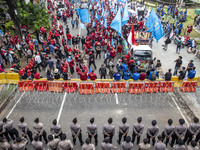 Jakarta, 01 May 2019 : Police guard with wire to stop labors approach Indonesian Palace. Thousands of Labor filled Merdeka Barat Street Jaka...