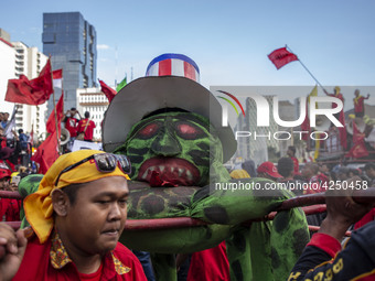 Jakarta, 01 May 2019 : Puppet with USA Flag represent capitalism were lifted up during the dance ceremony at the demonstration location. Tho...