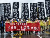 Protesters posing with banners and flags calling for more holidays, paid leave, more labour rights protections. During 2019 Labor Day March...