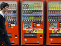 People purchase bottle drinks from a vending machine on  Feb. 12, 2015 in Tokyo, Japan. Around half of the vending machines in Japan sell dr...