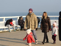 Gdynia, Poland 14th, Feb. 2015 People enjoy sunny and warm weather walking along the Baltic Sea coast and Orlowo Pier in Gdynia Orlowo. Mete...