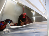 A Palestinian woman Inspects a container as a temporary replacement for their house that was destroyed by what they said was Israeli shellin...