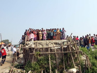 A large crowd gathers near Manikganj, western Bangladesh 23 February 2015 as the ferry that capsized in the Padma River 22 Feb is brought as...