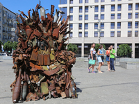 People walk past the iron Throne installed at Independence Square in Kyiv,  Ukraine,  June 25, 2019. 