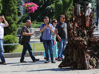 People take pictures of iron Throne installed at Independence Square in Kyiv,  Ukraine,  June 25, 2019. 