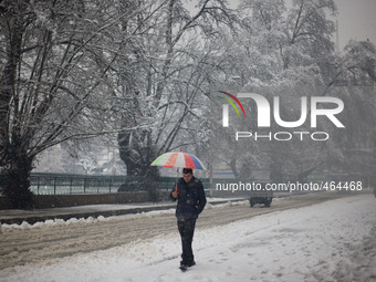 SRINAGAR, INDIAN ADMINISTERED KASHMIR, INDIA - MARCH 02: A Kashmiri man holds an umbrella as he walks during a fresh snowfall on March 2, 20...