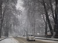 SRINAGAR, INDIAN ADMINISTERED KASHMIR, INDIA - MARCH 02: A vehicle moves on a snow covered road during a fresh snowfall on March 2, 2015 in...