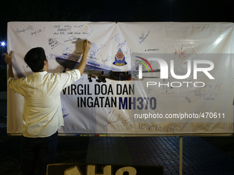 A man writes a message on a board for the missing Malaysian Airlines MH370 in Petaling Jaya near Kuala Lumpur, Malaysia 6 March 2015. On 8 J...