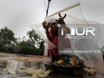 An Indian Women shields herself from rain with a plastic sheet on the eve of International Women Day in New Delhi on March 7,2015.Internatio...