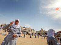 Palestinian school children fly kites to show solidarity with the Japanese people, near the Japan-funded housing project in Khan Younis in t...