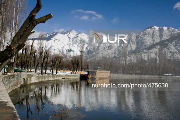 SRINAGAR, KASHMIR, INDIA - MARCH 10: Snow capped Zabarvan mountains are reflected in Dal lake  on March 10, 2015 in Srinagar, the summer cap...