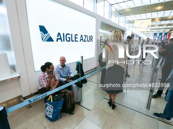 Passengers wait in front of the French airline Aigle Azur’s reception desk, without any employees, at Orly airport, France  on September 6,...