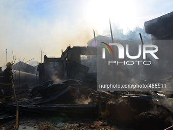 Fire fighters withstands the heat as they try to put out the fire that engulfed over 300 houses in Cebu City today March 17 2015.
 (
