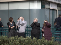 People watching the solar eclipse, when the moon obscured the sun for a short time, in central Stockport. (