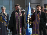 Chaplain blesses flags and standards and sprinkles soldiers with holy water. Ukraine marks the first anniversary of the first volunteering G...