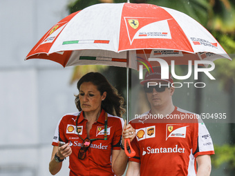 Finnish Kimi Raikkonen (R) of Scuderia Ferrari walks with his team member during the Malaysian Formula One Grand Prix at Sepang Internationa...