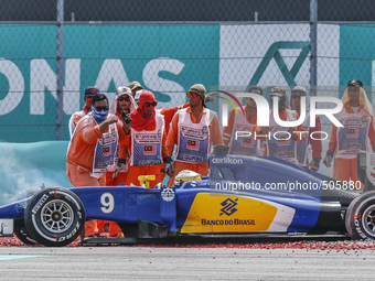 Track Marshall assist Swedish Marcus Ericsson of Sauber F1 Team car during the Malaysian Formula One Grand Prix at Sepang International Circ...