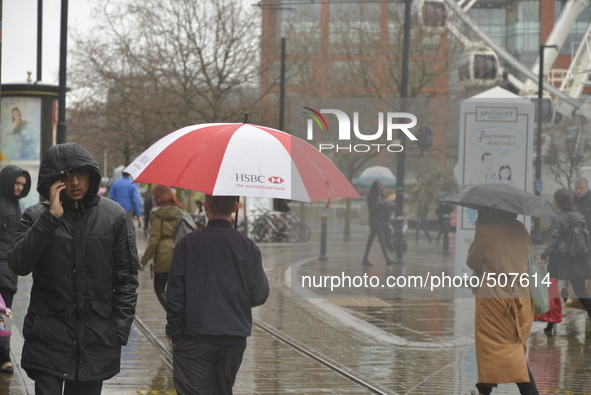 People sheltering underneath umbrellas, due to the heavy rain, on Monday 30th March 2015. 