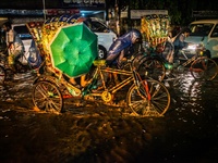 People are going home through a water logged street after the rain breaks at Dhaka, Bangladesh, 4 April, 2015. (