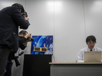 Members of the media take photograph of the miniature satellites payload comprise two of Japans most popular animated characters  Mobile Sui...