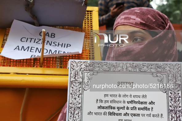A woman holds a playcard during a protest against the citizenship amendment bill in New Delhi India on 10 December 2019.  