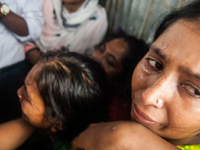 A women is cries with her family members at the Mawa Ferry Ghat near Dhaka, 4 August 2014 after her husband and two son went missing after t...