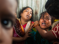 Two women cry for their missing husbands at the Mawa Ferry Ghat near Dhaka, 3 August 2014  after the sinking of the Pinak-6 passenger vessel...