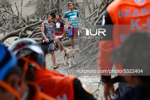 Locals wait for rescuers at the foot of Taal Volcano Island in Batangas province, south of Manila on January 14, 2020. People living by the...