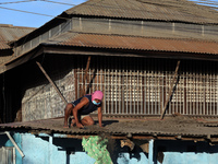 A man cleans his home covered with volcanic ash in Talisay, in the province of Batangas on 16 January 2020. Taal volcano slighly waned its a...