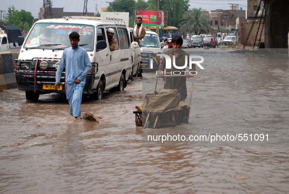 LAHORE, April 28, 2015 () -- People wade through a flooded area after heavy rain in northwest Pakistan's Peshawar, April 28, 2015. At least...