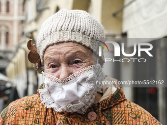 An elderly lady, who went to the market in Piazza delle Erbe for shopping, wears a mask made by her at home to protect herself from the prob...