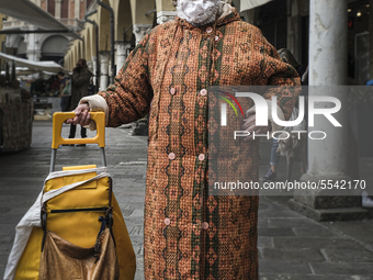 An elderly lady, who went to the market in Piazza delle Erbe for shopping, wears a mask made by her at home to protect herself from the prob...