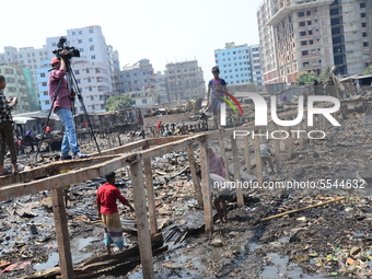 Bangladeshi Slum-dwellers have seen searching for their household belongings after a devastating fire that broke out at Rupnagar slum on Mar...