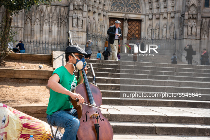 Street musician plays while he is wearing a mask in front of Barcelona Cathedral it in Barcelona, Spain, on March 14, 2020. (Photo by Adria...