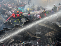 Firefighters and local people work to extinguish a fire at a Jhutpatti slum at Mirpur in Dhaka, Bangladesh, on March 14, 2020. A fire that b...