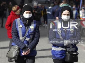 Female police officers wearing protective masks accompany a rally called 'March of Patriots' at the Volunteer Day in honor of volonteer figh...