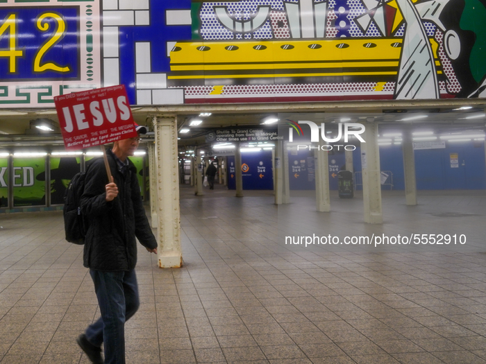 A man holding a religious sign in one of the busiest subway stations of Manhattan which is seen nearly empty due to COVID-19 novel coronavir...