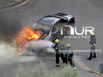 Firefighters try to extinguish a fire in a car in Cascais, Portugal, on March 26, 2020. (